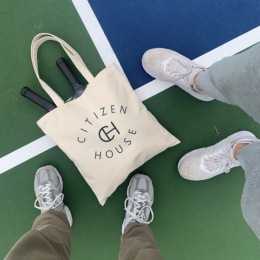 two people standing beside a branded bag
